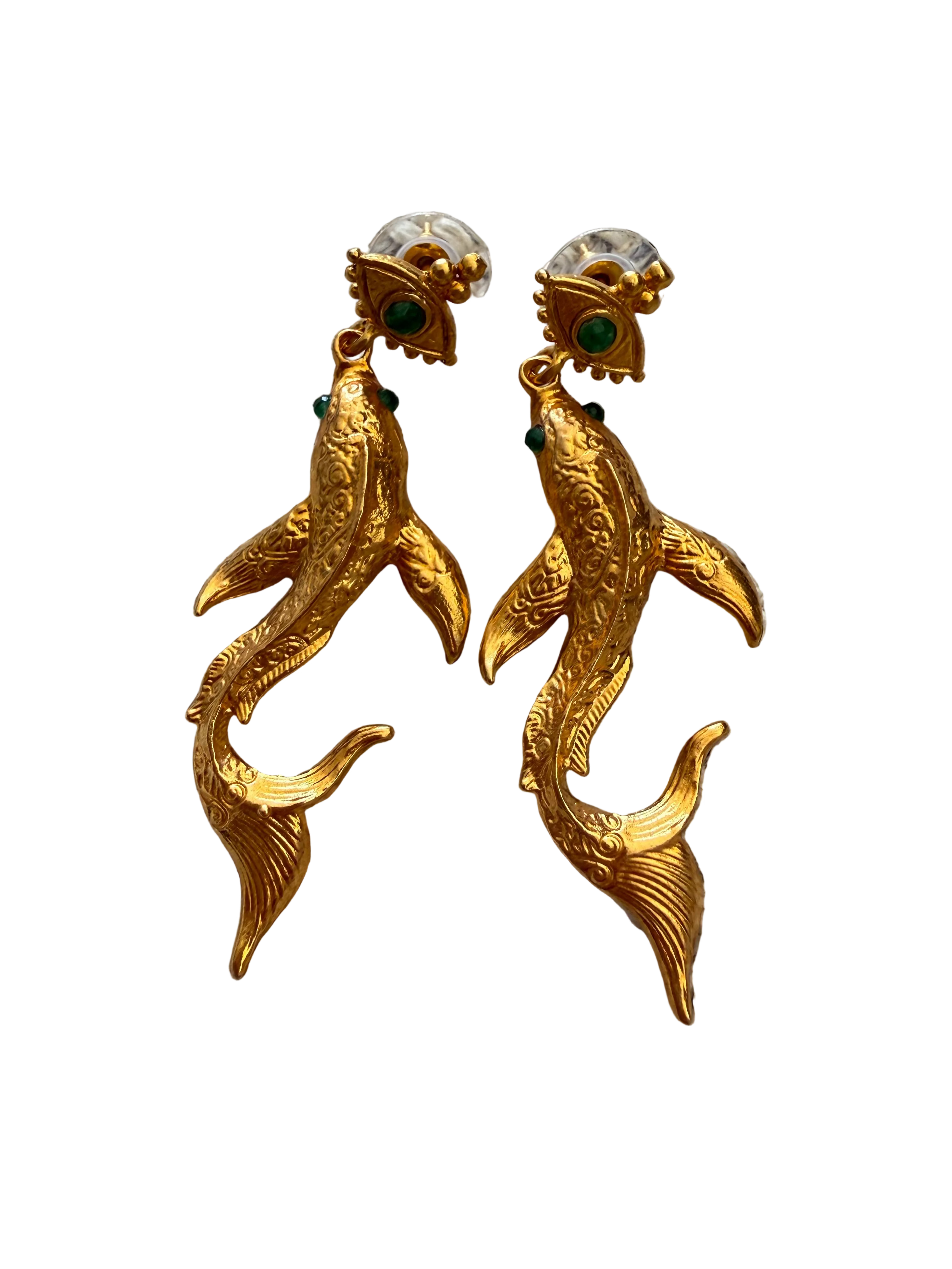 Pair of gold dolphin earrings on a textured fabric background